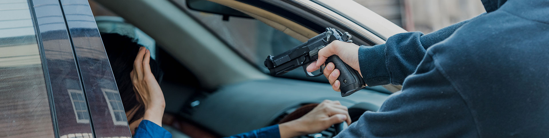 A man pointing his gun to the lady driver